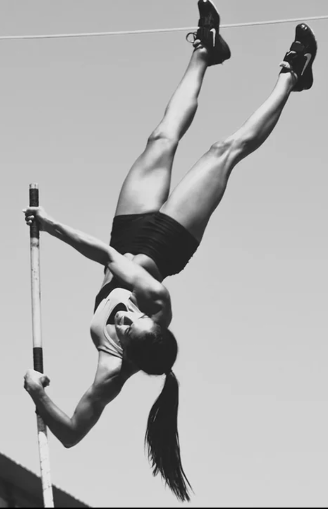 Auto-generated description: An athlete is captured mid-air while performing a pole vault.