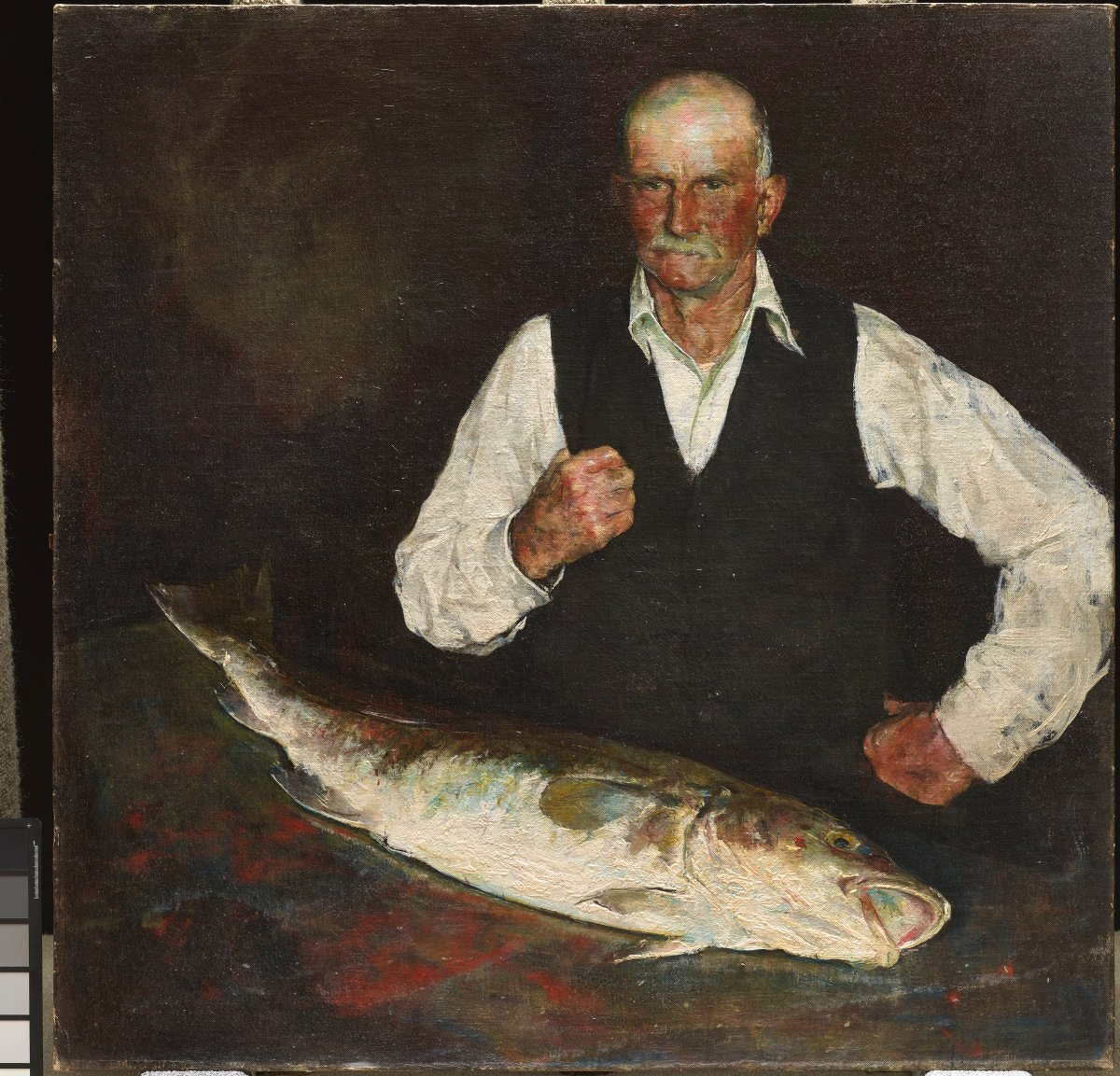 An oil painting by Charles Webster Hawthorne (American, 1872 - 1930) of a stern-looking elderly man with a mustache standing next to a large fish lying on a table against a dark background. From the collection of the Dallas Museum of Art.